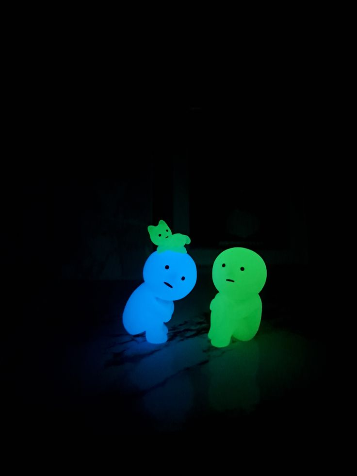 Two glowing figures in blue and green